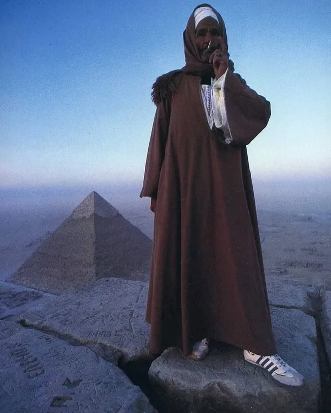 This 1981 photo captures an Egyptian man smoking a cigarette while standing atop the Great Pyramid of Giza.